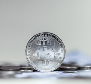 Close-up of physical silver Bitcoin tokens on a silver surface.