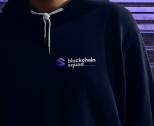 Man wearing a dark hoodie with the Blockchain Squad logo.