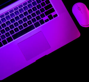 Close-up of MacBook keyboard and mouse with Blockchain Squad branding.