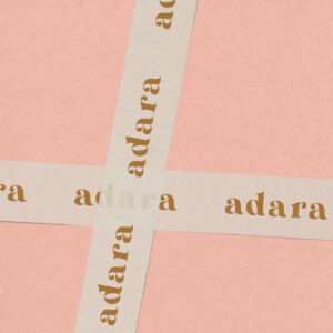 Pink box with adara-branded masking tape featuring the logo in brown.