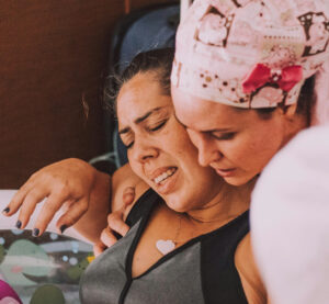 Midwife assisting in a water birth, symbolizing ClientCare’s dedication to empowering birth professionals.