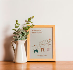 Wooden table with a framed illustration of teamwork and a vase with green foliage.