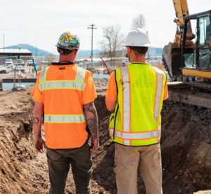 Engineers overlooking a construction site with machinery.