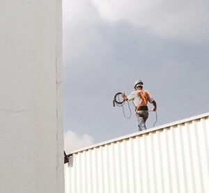 Worker walking on a rooftop at a construction site.