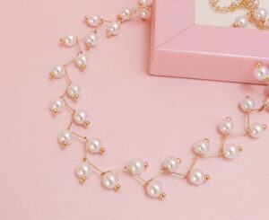 Zigzag pearl necklace on a pink frame with a pastel background.