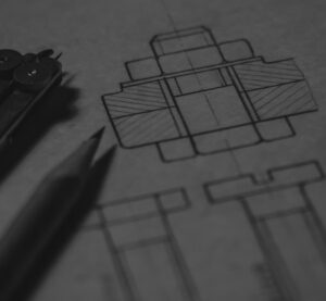 Architectural blueprint with a compass and pencil in grayscale.