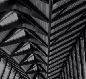 Grayscale close-up of geometric ceiling details in modern architecture.