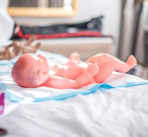 Realistic White newborn mannequin used in midwifery training programs.