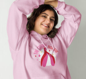 Woman wearing the “Clitoral Hoodie” featuring a kawaii-style clitoral illustration. Midwifery Wisdom Collective Visual Identity.