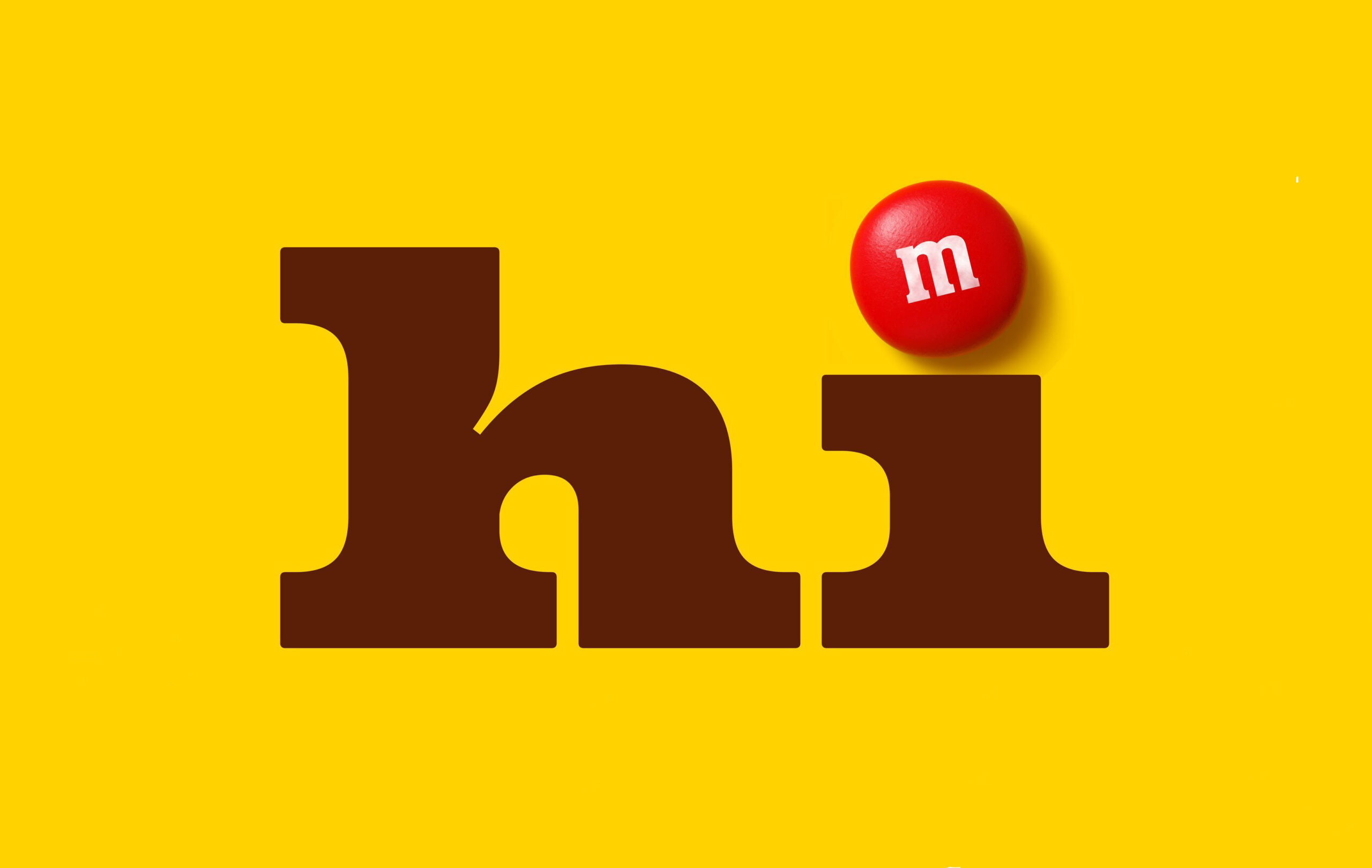 The word “hi” in M&M’s signature typography, with a red M&M dotting the “i,” set against a yellow background. how to find your brand voice