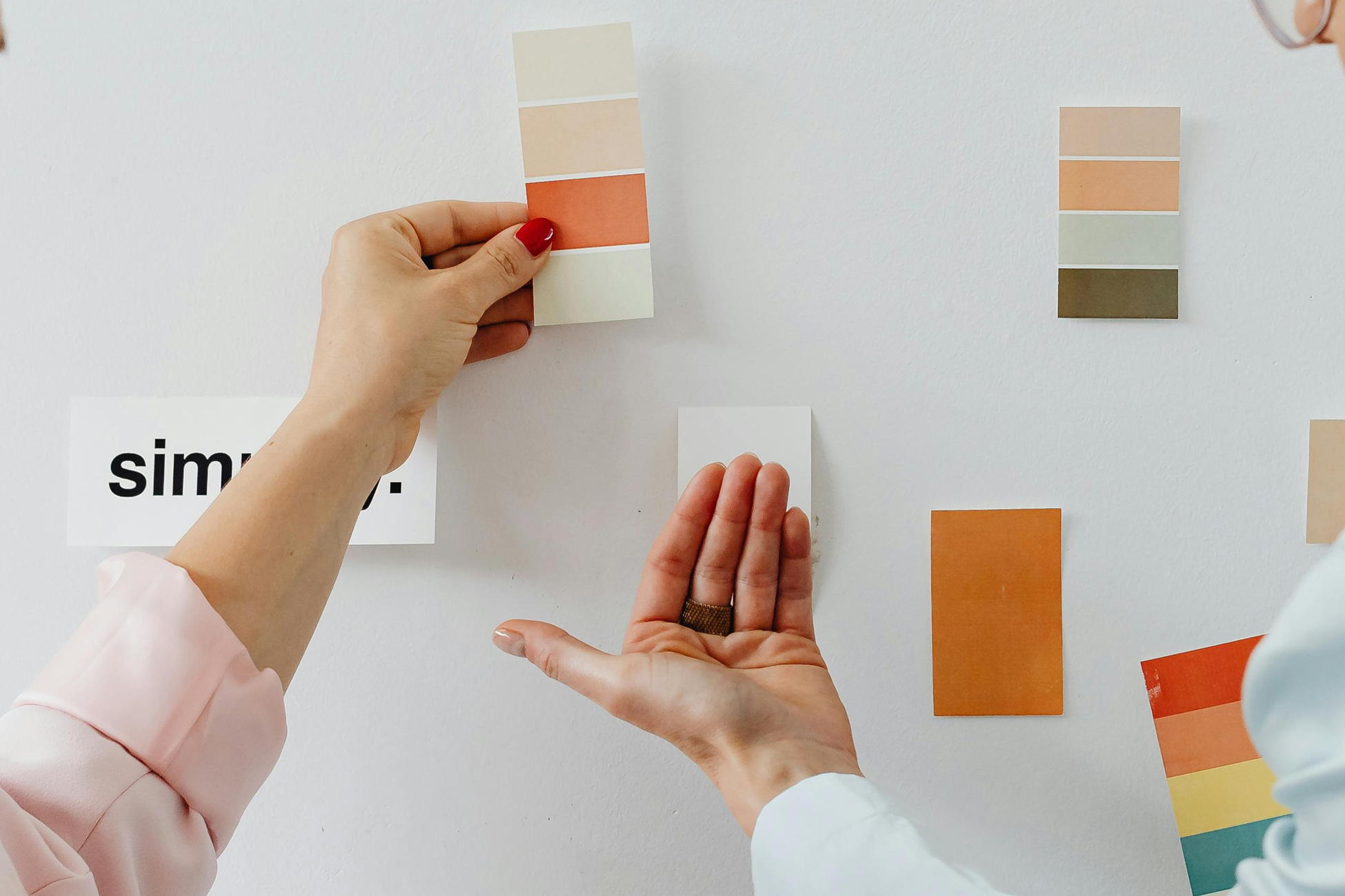 Designer and client reviewing color palette options on a wall – Branding Basics FAQs