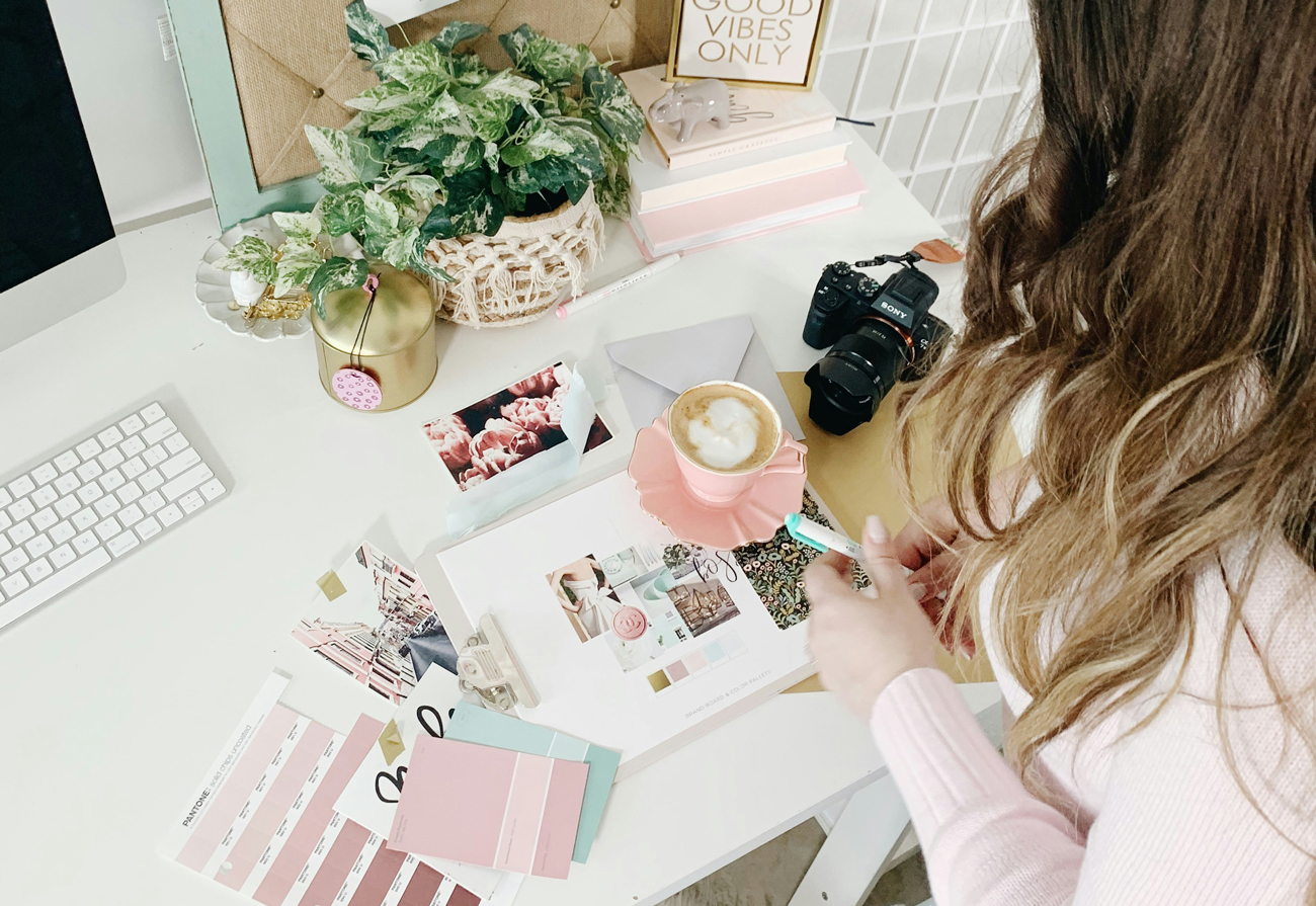 Woman analyzing mood boards and color palettes on a desk, making strategic branding improvements.