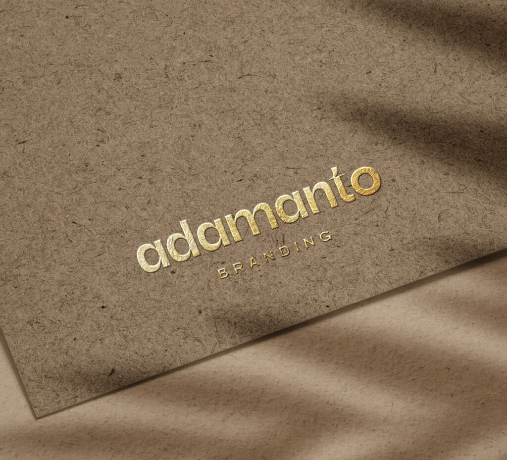 adamanto logo printed in gold foil on textured brown paper.