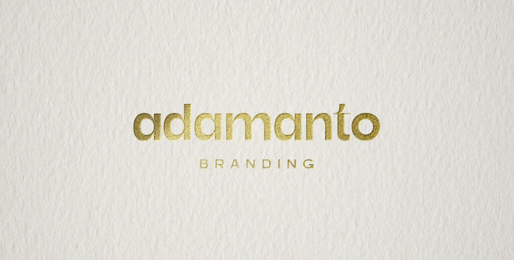 adamanto logo printed in granulated gold foil on porcelain textured paper.