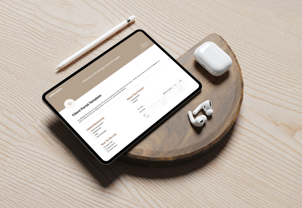 iPad showing adamanto client portal in Notion on a wooden surface with AirPods and pencil.