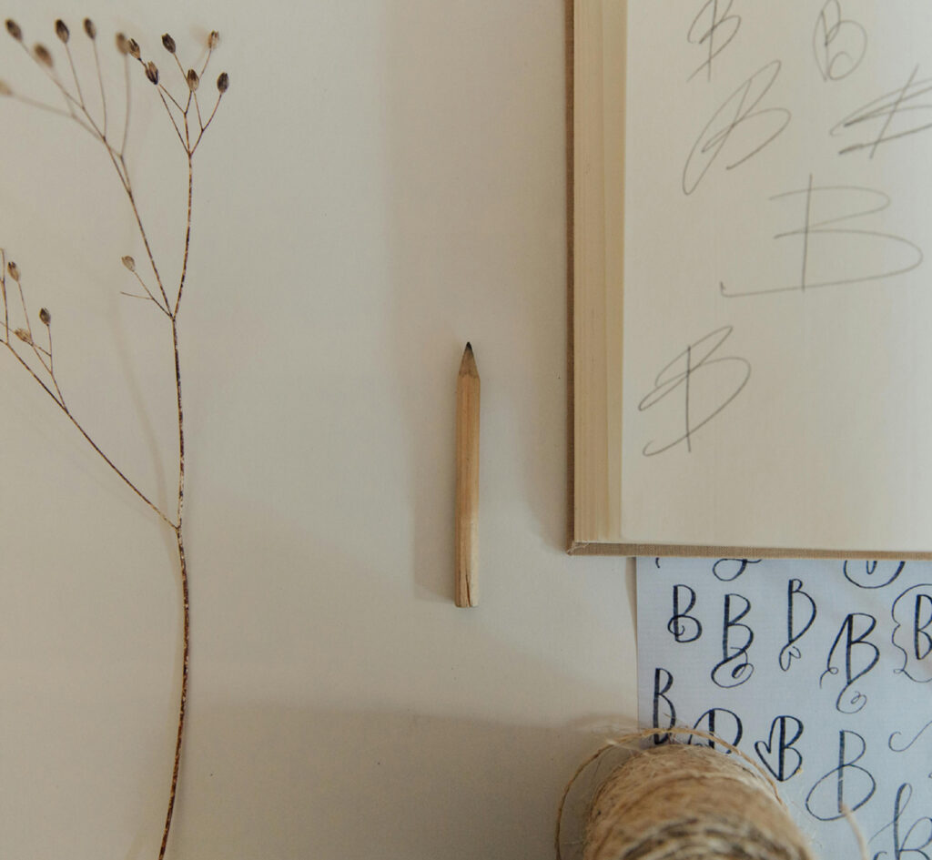 Pencil sketches of the letter B on paper during brand identity development process.