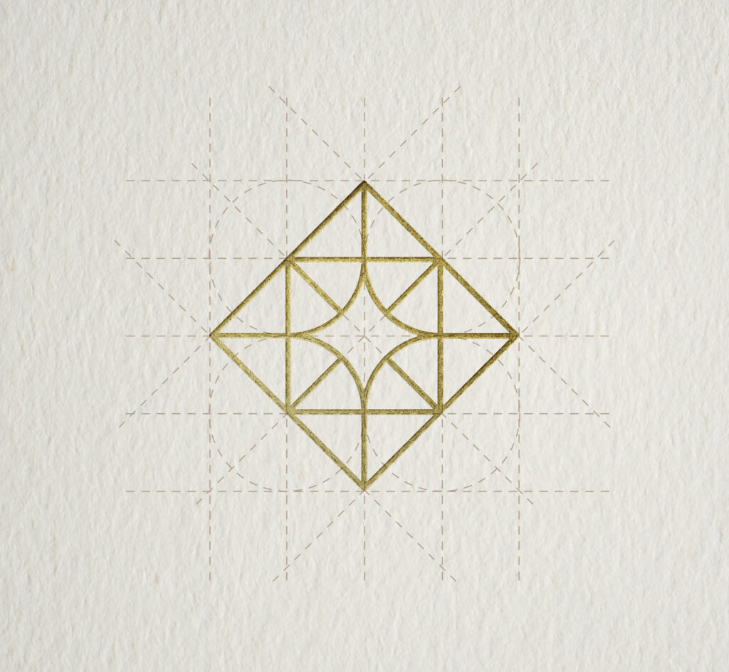 Geometric construction of the adamanto symbol with gold foil print and visible grid lines.