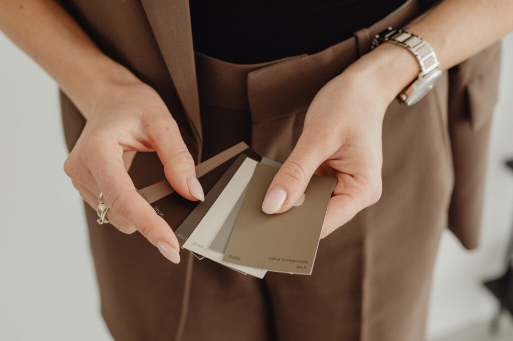 Hands holding neutral color swatches showing how to fix my branding through color palette refinement